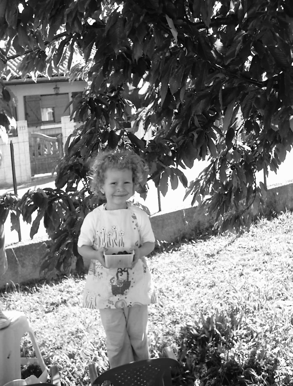 Théa, petite fille, sous un arbre dans le jardin